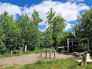 A park with a wooden structure, benches, and a gravel path. - 4 Star Holiday Home in Skovde (Skovde)