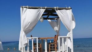 A beach cabana with a wooden deck and white curtains, overlooking the sea. - Korell 2 Modern Retreat (Sint Maarten)