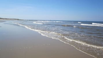 Une plage dotée d’un large rivage sablonneux et de vagues douces.