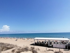 A beach with a white tented area, sandy dunes, and the ocean. - Korell 2 Modern Retreat (Sint Maarten)