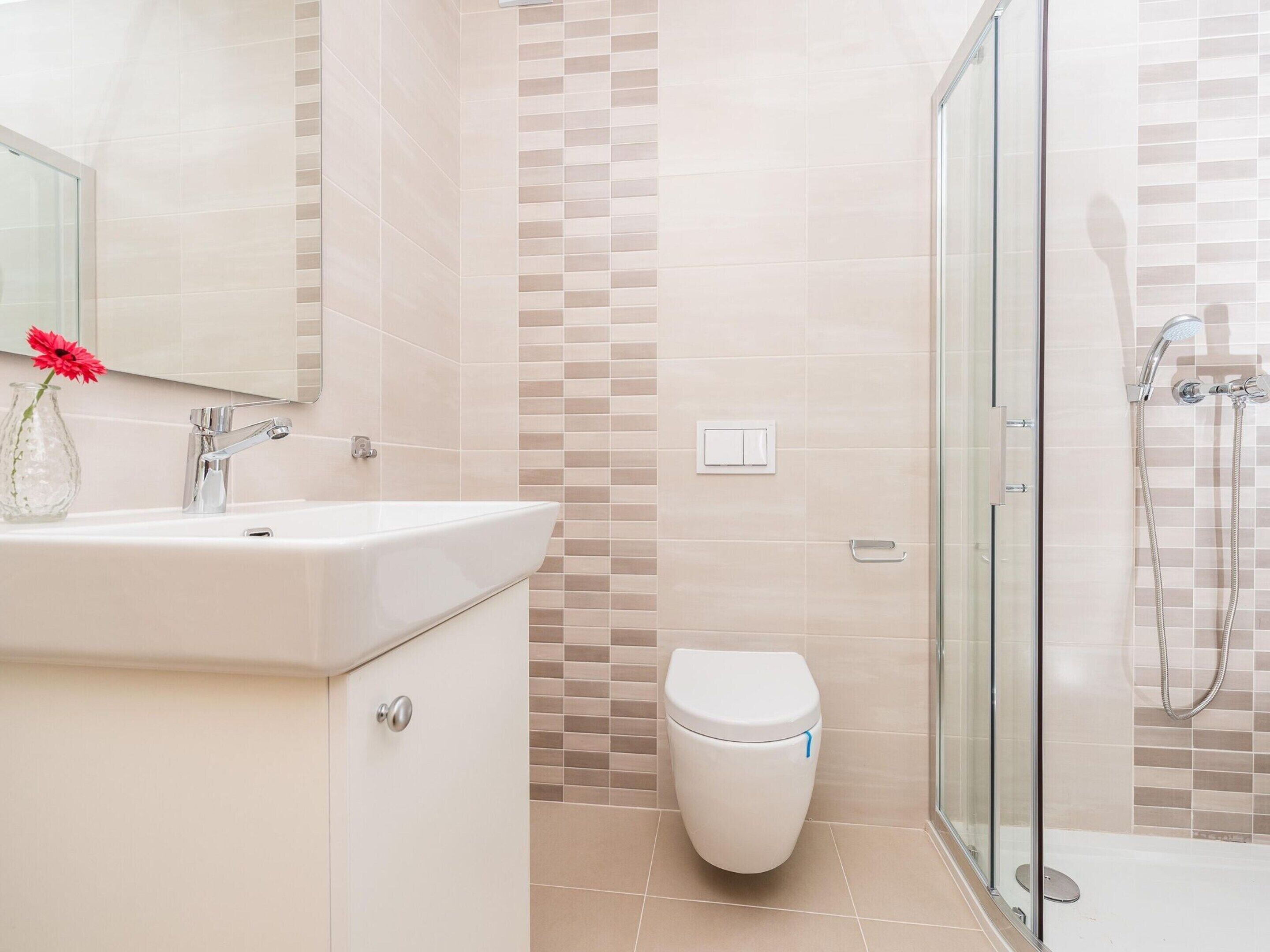 A bathroom with a sink, toilet, and shower.