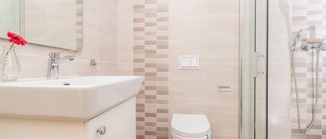 A bathroom with a sink, toilet, and shower.