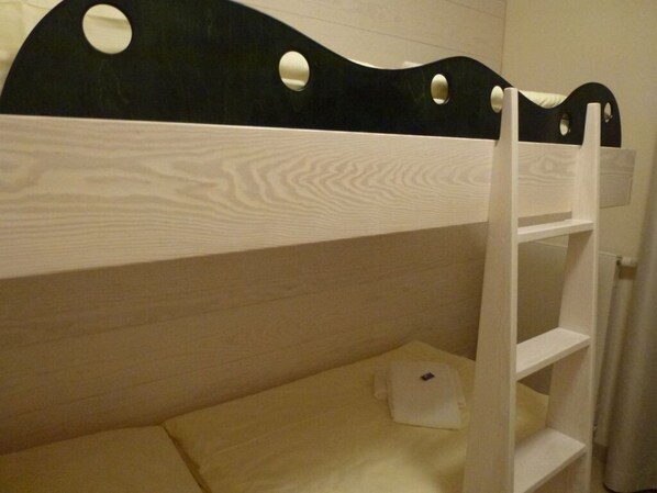 A bunk bed with a wooden headboard and a ladder. - Deck 2 Modern Retreat (Timmendorfer Strand)