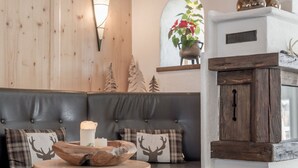Un rincón acogedor con asientos, una pared de madera, una lámpara decorativa y una planta.