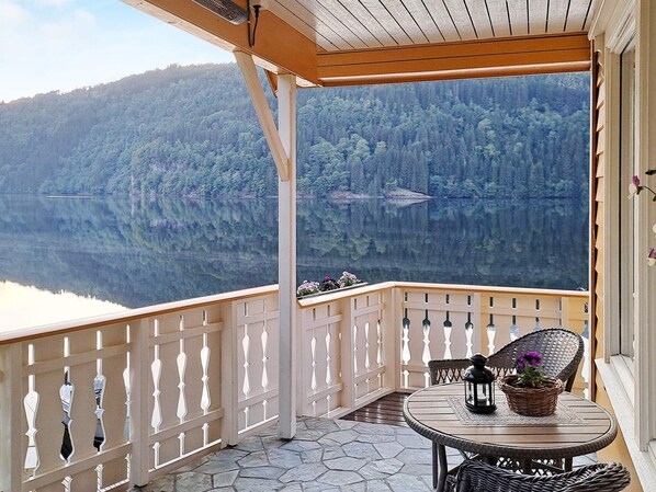 A balcony with a view of a lake and forest. - 8 Person Holiday Home in Bygstad (Sunnfjord)