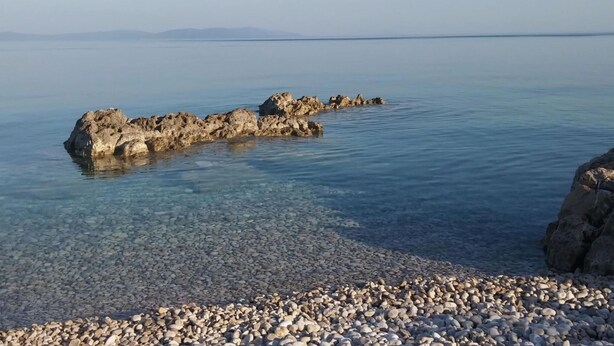 A pebbly beach with clear water and rocky formations. - Charming Apartment in Rasa-labin (Rasa)