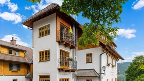 Un immeuble à plusieurs étages doté d’un balcon, d’une enseigne indiquant la présence d’un restaurant et offrant une vue sur les environs.