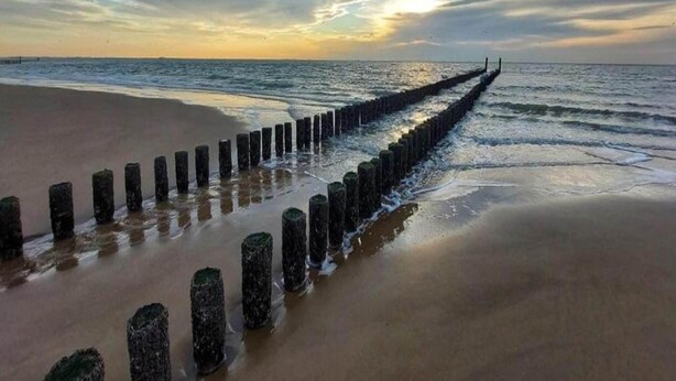 A beach with a wooden groyne extending into the sea, under a cloudy sky. - Tranquil Ground-floor Hideaway (Koudekerke)