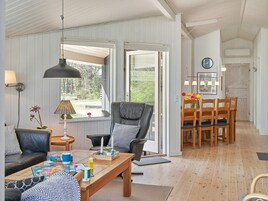 A cozy living area with a sofa, a table with board games, a chair, and a dining set.