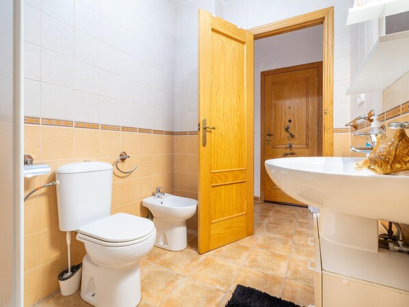 Casa de banho com sanita, bidé e lavatório.