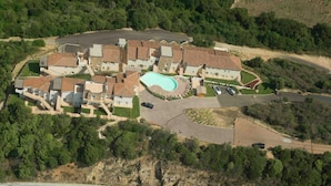 An aerial view of a residential area with multiple houses, a swimming pool, and surrounding greenery. - Holiday Home in Baja Sardinia With Pool (Arzachena)