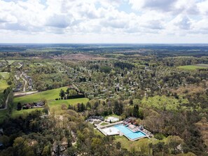 An aerial view of a residential area with a swimming pool complex surrounded by dense forest and scattered houses. - Beautiful Lodge in Appelscha With Terrace (Appelscha)