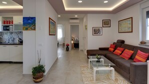 A modern living room with a sofa, coffee table, and artwork on the walls. - Apartment in Croatia Near Stunning Coastline (Medulin)