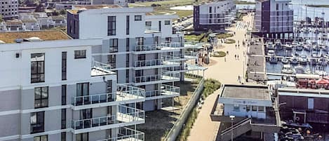 Ein modernes Wohngebiet mit mehrstöckigen Gebäuden, einem Yachthafen und freiem Blick auf das Meer.