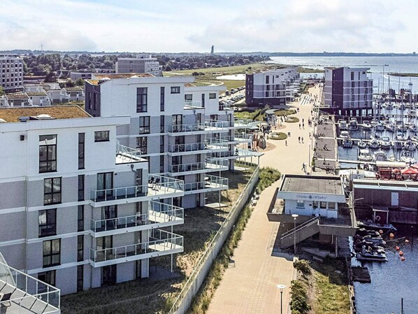 Ett modernt bostadsområde med flerfamiljshus, en småbåtshamn och fri utsikt över havet.