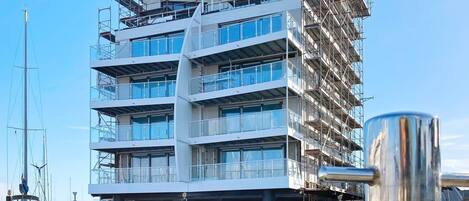 A multi-story building with a modern architectural design, located over a body of water.