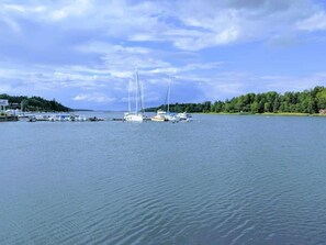 A marina with several sailboats docked, surrounded by a forested shoreline. - 7 Person Holiday Home in Grisslehamn (Grisslehamn)