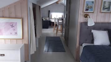 Un dormitorio con una cama, un escritorio y una silla al fondo.