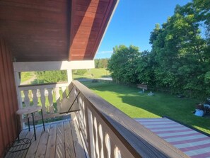A wooden deck with a railing, a small table, and a bench. - 7 Person Holiday Home in Grisslehamn (Grisslehamn)