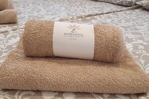 A rolled beige towel with a label that reads "SUNNYPOOL." - Sunny Pool Apartments - One Bedroom Apartment With Sea View (Jasenice)