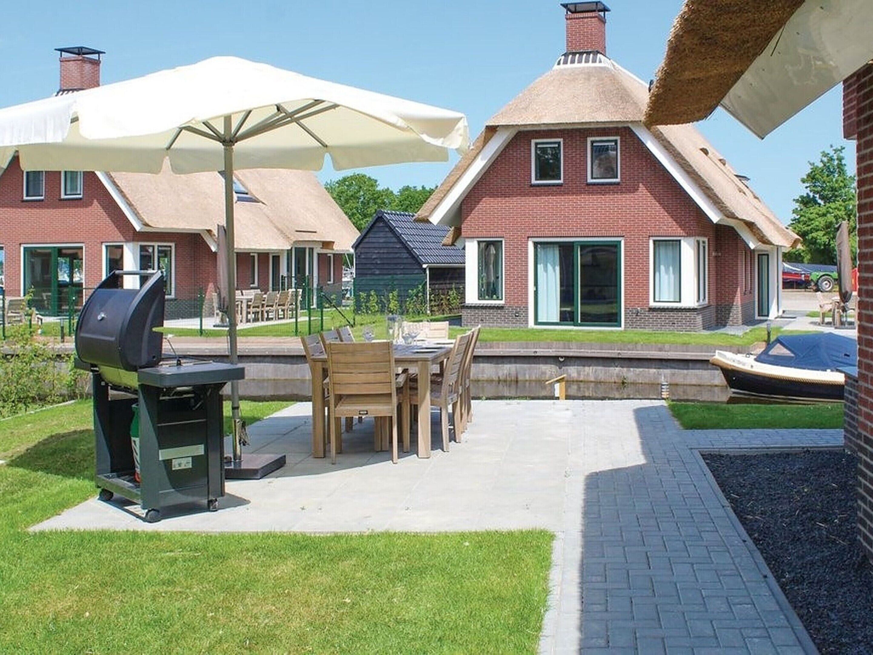 A patio area with a grill, outdoor furniture, and a boat dock.