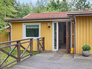 A wooden deck leading to a yellow building with a red-tiled roof, a window, and a door. - 4 Person Holiday Home in Fjaras (Fjärås)