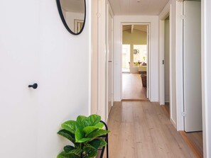 A hallway with a plant, a door, and a mirror on the wall. - 6 Person Holiday Home in Haderslev (Haderslev)