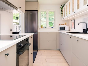 A modern kitchen with a stainless steel refrigerator, a microwave, and a kettle. - 6 Person Holiday Home in Haderslev (Haderslev)