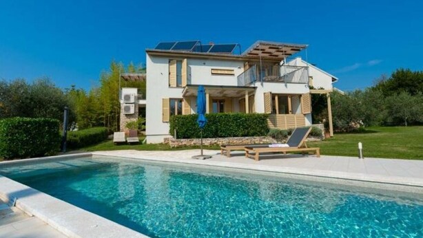A modern two-story house with a swimming pool, solar panels, and a covered patio area. - Apartment Casa Bamboo (Medulin)