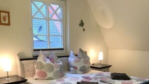A bedroom with a bed, bedside tables, a window, and a lamp. - Holiday Home Windfluchter (Graal Mueritz)