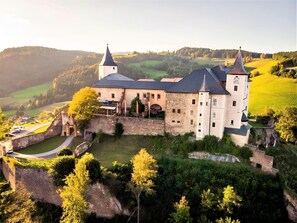 A castle with multiple towers, surrounded by lush greenery and a moat. - Tranquil Apartment in Polling With Terrace (Straßburg)