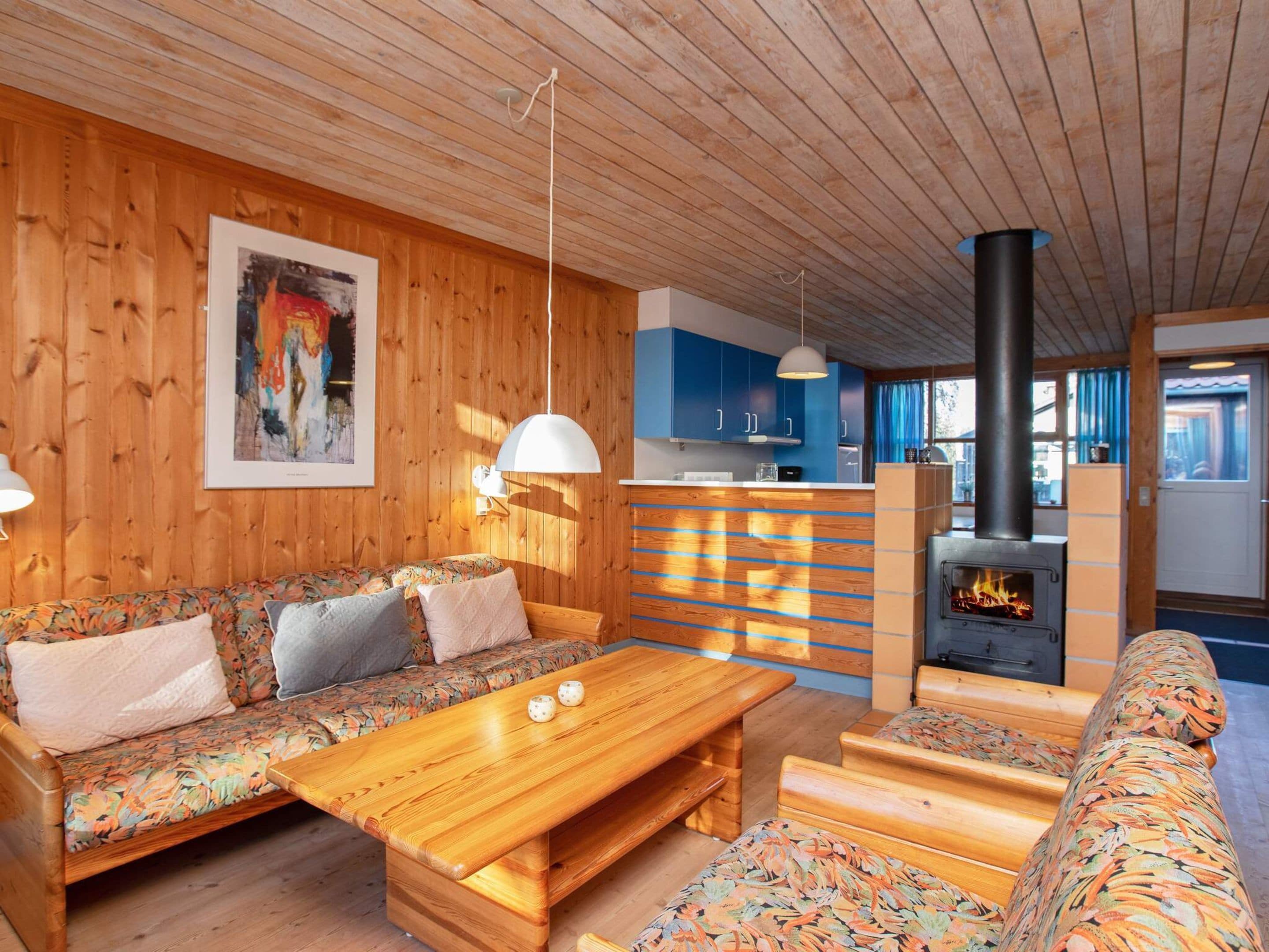 Ein gemütliches Holzinterieur mit einer Couch, einem Holztisch und einem Kamin.
