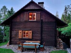 A rustic wooden cabin with a stone staircase leading up to the entrance, a bench with a table, and a window with shutters. - Alpine Hut in Murau Near Ski Slope (Sankt Georgen am Kreischberg)