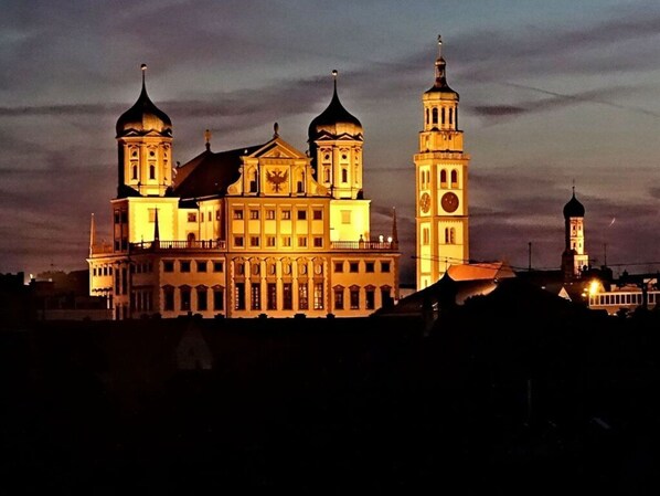 Un ampio edificio illuminato con numerose torri e cupole, probabilmente un edificio pubblico storico o di rilievo.