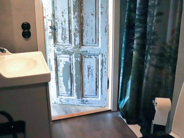A bathroom with a sink, a door, and a curtain. - 4 Person Holiday Home in Rolfstorp (Rolfstorp)