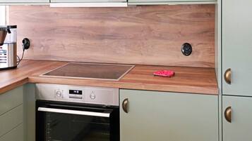 A kitchen with a built-in oven, a microwave, and a wooden countertop.