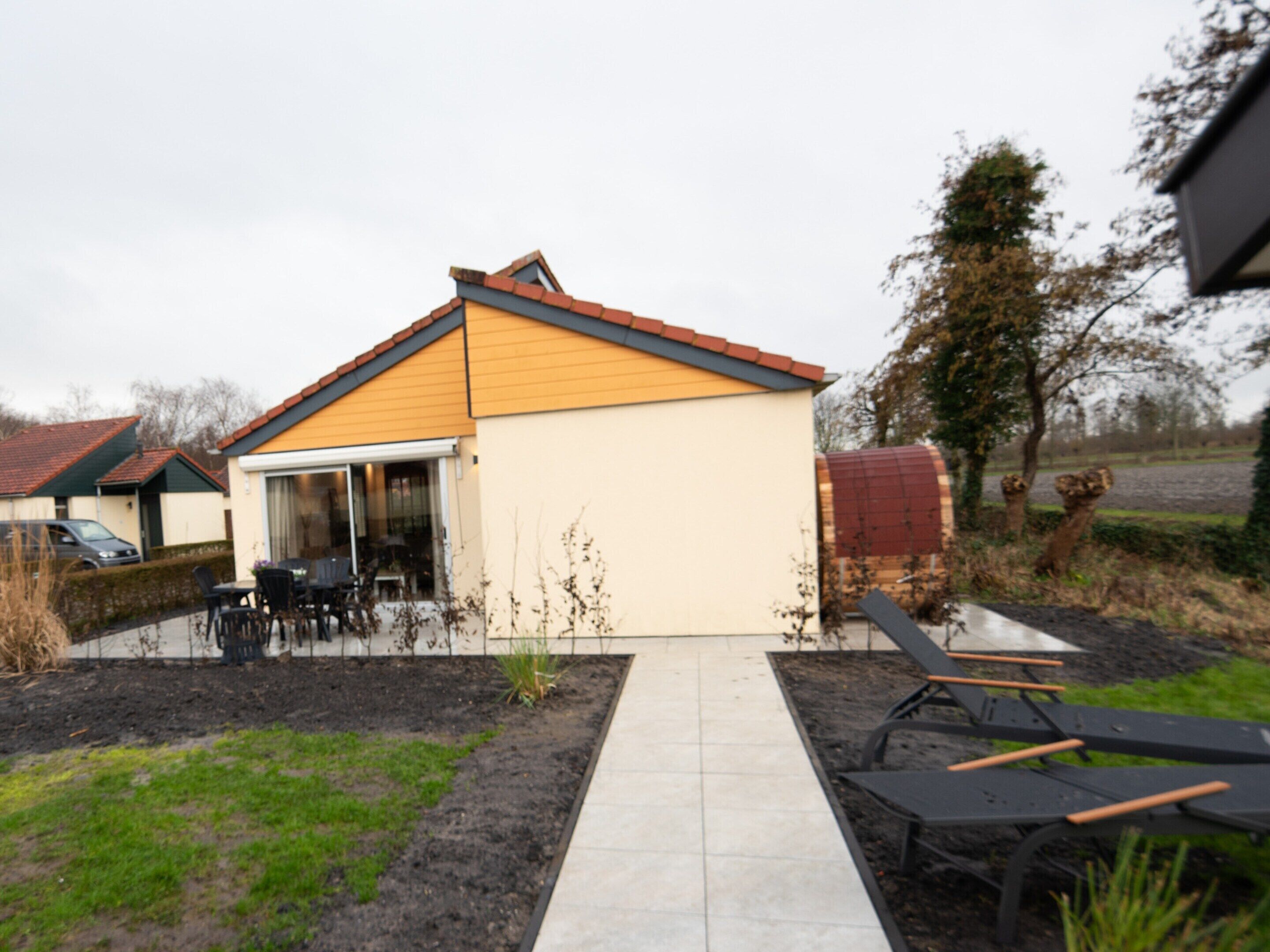 A house with a tiled patio, a small garden, and a lawn.