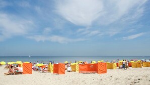 Une plage avec des parasols et des chaises de plage.