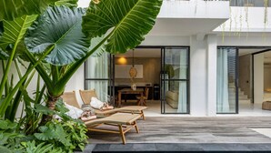 Uma casa moderna com piscina, plantas grandes e área de jantar.