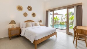 Ein Schlafzimmer mit großem Bett, Nachttischen, Blick auf einen Swimmingpool und einem Essbereich.