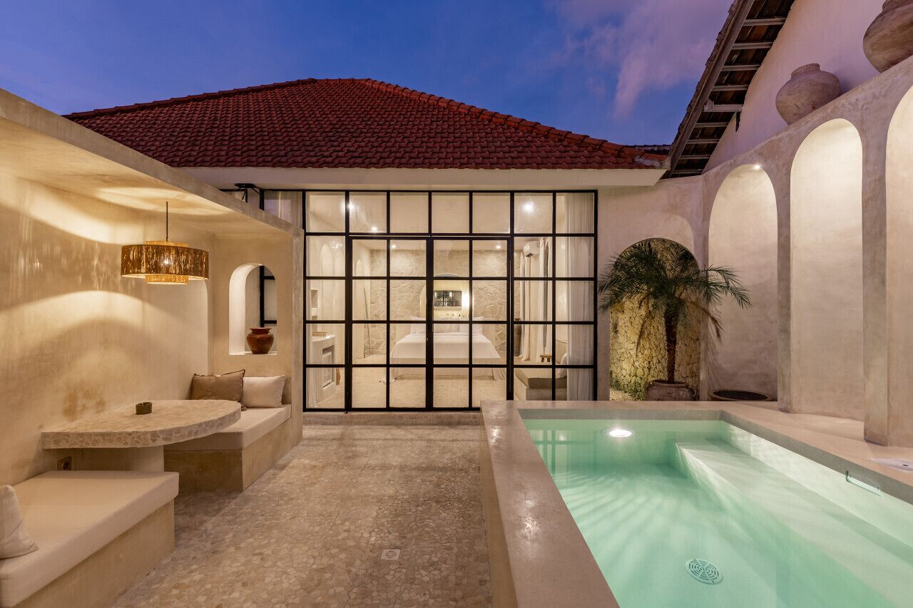 Zona de spa con piscina, asientos y vista al interior.