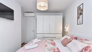 A modern bedroom with a bed, a flat-screen TV, a ceiling light, and a wall-mounted air conditioner. - Modern Villa With Private Hydromassage Pool (Vodnjan)