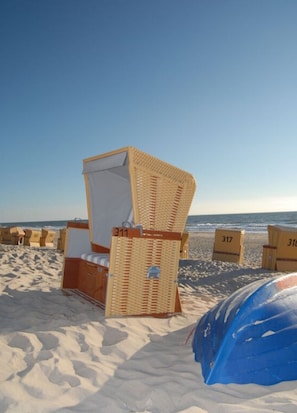A beach chair with a white cushion and a wicker frame, labeled with the number 311. - D Wilting in the House (Wenningstedt-Braderup)