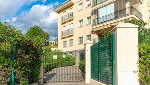 A multi-story residential building with balconies, a gated entrance, and a clear sky. - Belvilla by OYO Casa Roberto (Mijas)