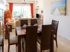 A dining area with a table set for four, surrounded by chairs. - Belvilla by OYO Casa Roberto (Mijas)