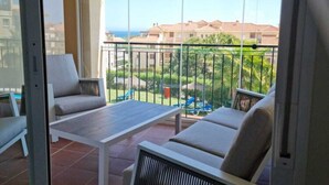 A balcony with a table and two chairs, a view of a residential area, and a clear sky. - Belvilla by OYO Casa Roberto (Mijas)