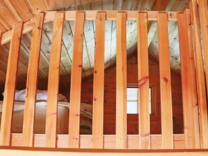 Un plafond en bois avec un motif à lattes, qui fait probablement partie de la structure intérieure d’un bâtiment.