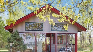 Un bâtiment en bois à deux étages, doté de grandes fenêtres et d’un toit rouge.