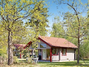 A modern house with a red roof, large windows, and a well-maintained lawn. - 5 Person Holiday Home in Bastad (Bastad)