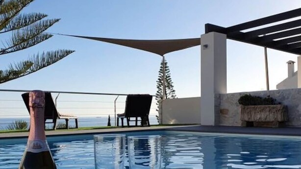 A pool area with a bottle of wine and two glasses on a table, overlooking a scenic view. - Jose Comfortable Holiday Residence (Rincon de la Victoria)